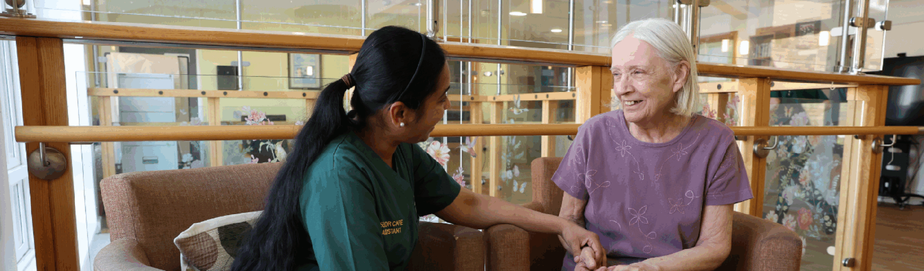 Female care home resident chatting to carer
